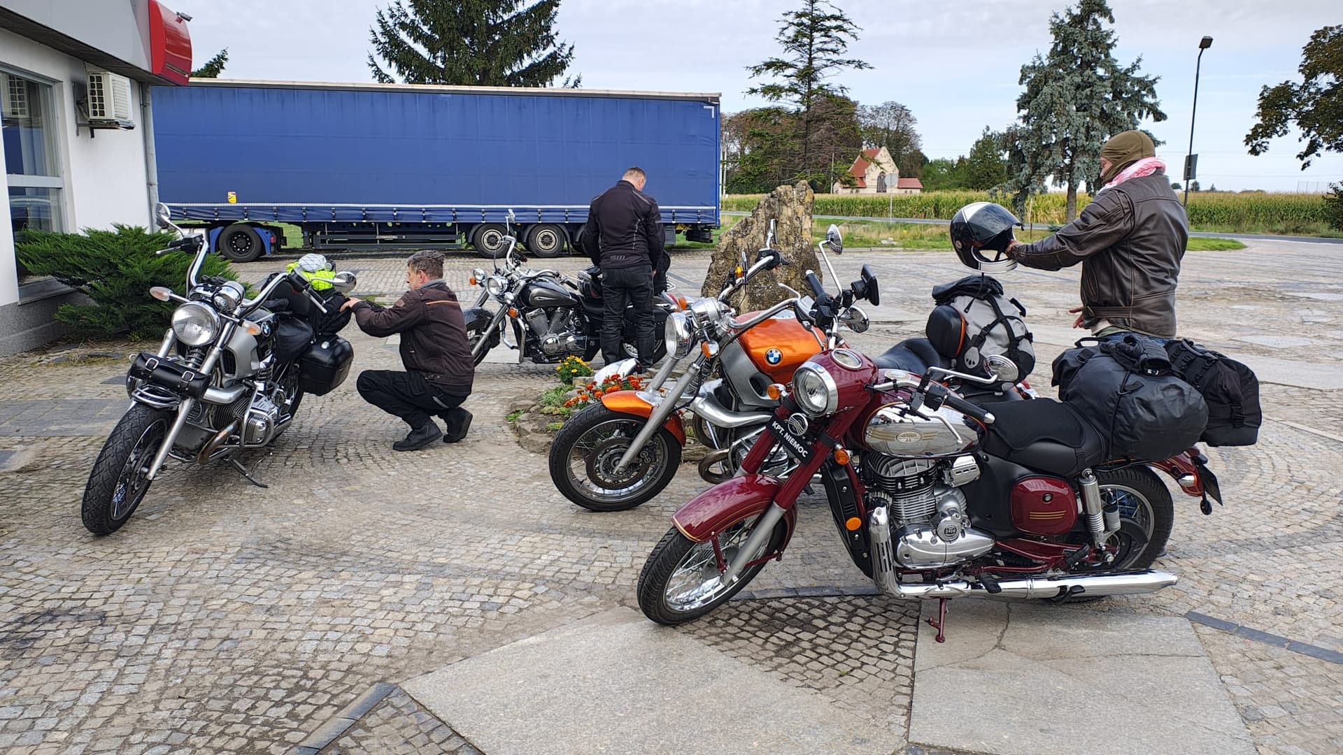 Uczestnicy wyprawy i motocykle podczas postoju pod budynkiem